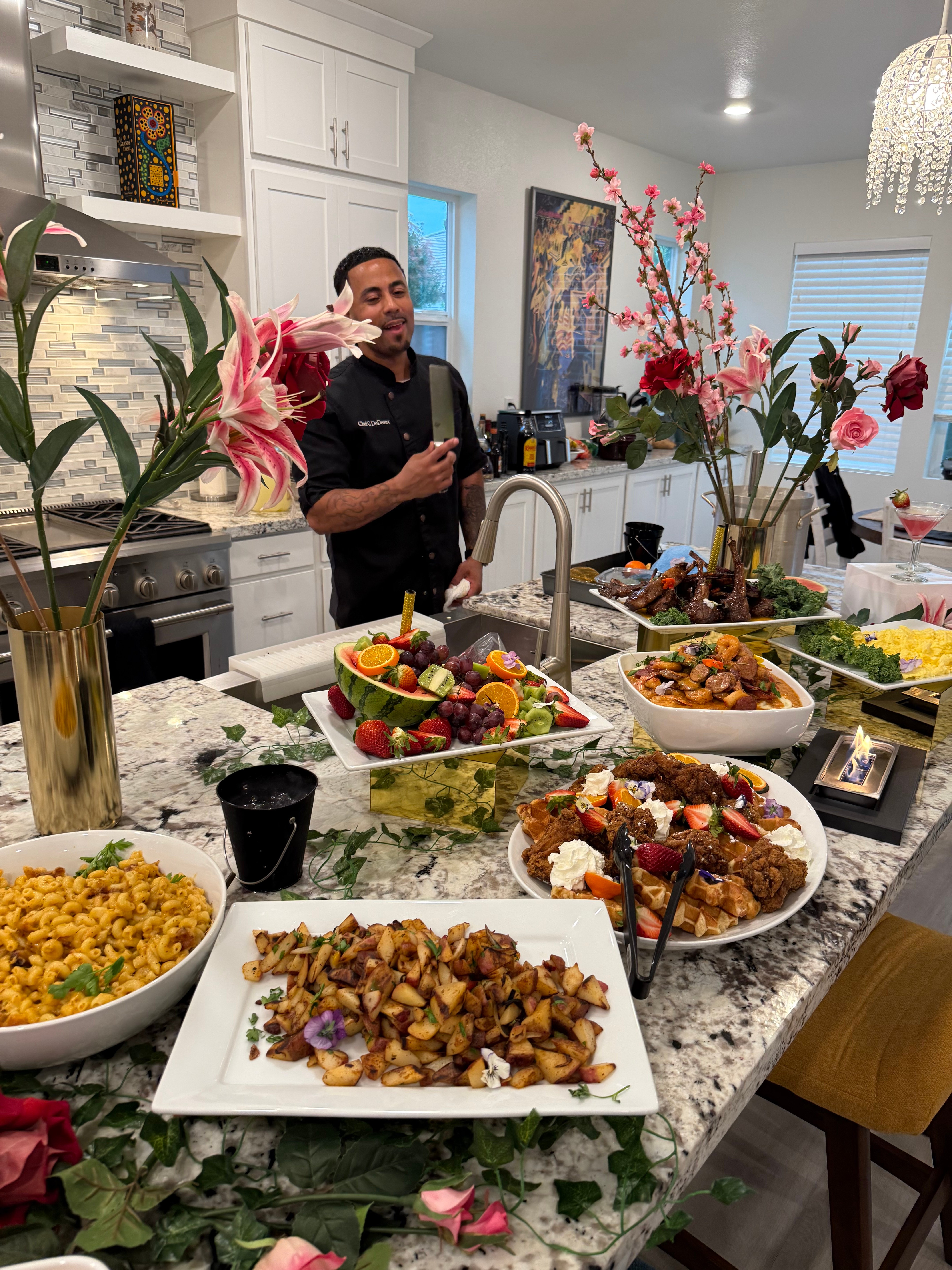 Smiling private chef presenting gourmet buffet with vibrant decor.